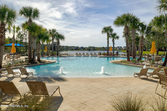 view of swimming pool featuring a patio, pool water feature, and a water view