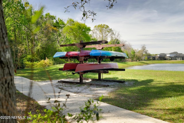 surrounding community featuring a water view and a lawn