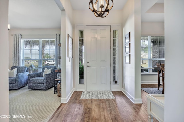 foyer entrance featuring hardwood / wood-style floors and a notable chandelier