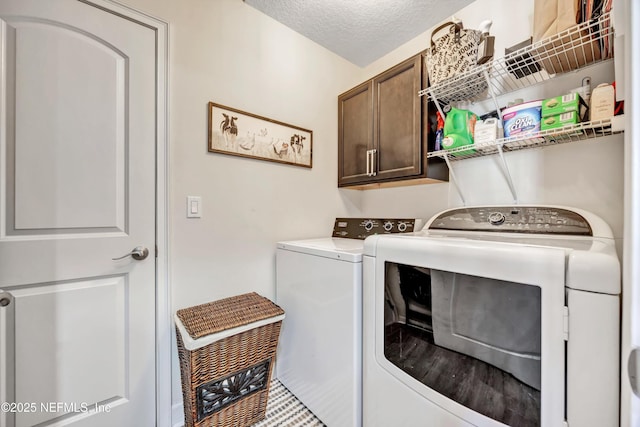 laundry room featuring cabinets, independent washer and dryer, and a textured ceiling