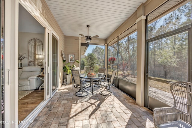 sunroom / solarium featuring ceiling fan