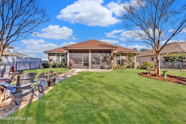 rear view of property featuring a sunroom and a yard