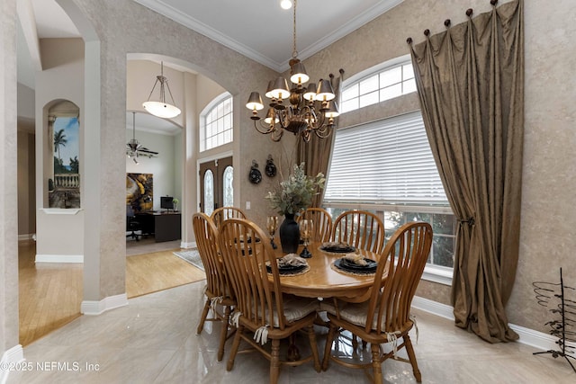 dining space with ornamental molding and an inviting chandelier