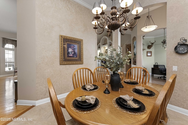 dining space with light tile patterned floors, an inviting chandelier, and ornamental molding