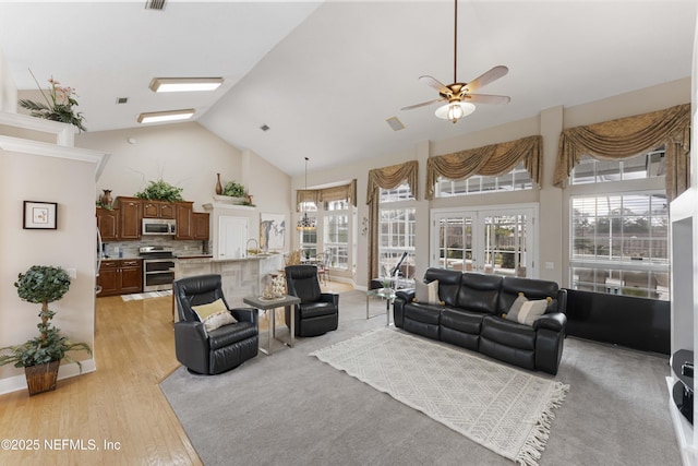 living room featuring ceiling fan, high vaulted ceiling, and light hardwood / wood-style flooring