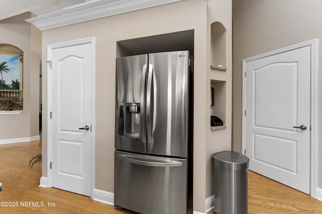 kitchen featuring stainless steel fridge with ice dispenser, ornamental molding, and hardwood / wood-style floors