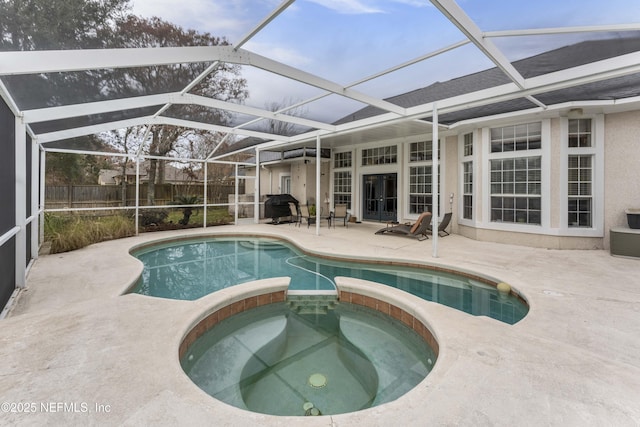 view of pool with a lanai, an in ground hot tub, and a patio