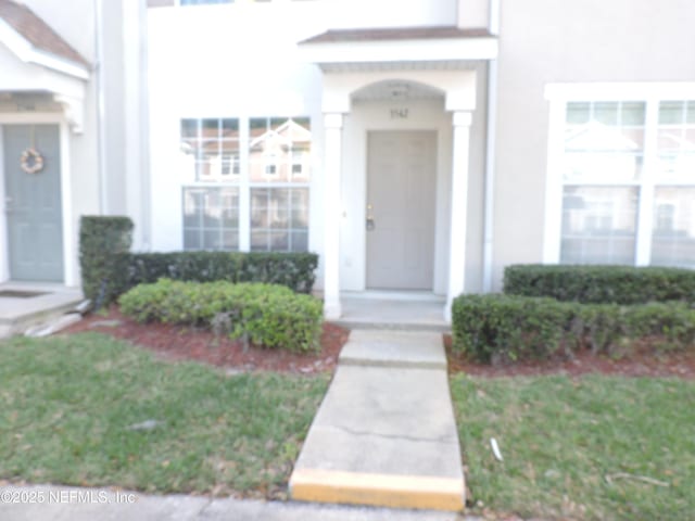 view of exterior entry with a yard