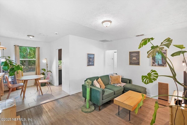 living room with light hardwood / wood-style floors and a textured ceiling