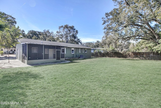 back of house with a sunroom and a yard