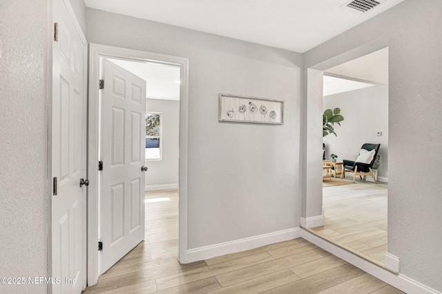 hallway with light hardwood / wood-style floors