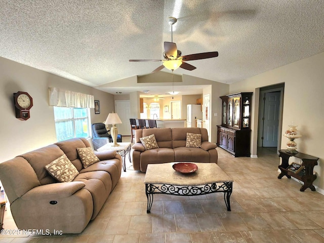 living room featuring a textured ceiling, ceiling fan, and lofted ceiling