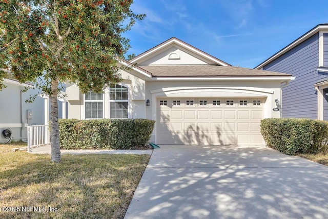 view of front of property with a garage and a front lawn