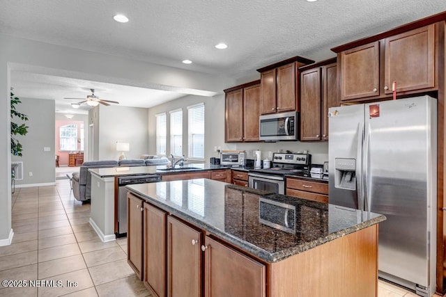 kitchen with a wealth of natural light, sink, a center island, kitchen peninsula, and stainless steel appliances