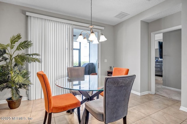 dining space with light tile patterned flooring and a textured ceiling