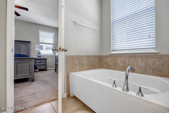 bathroom with a bathtub, tile patterned floors, and a textured ceiling