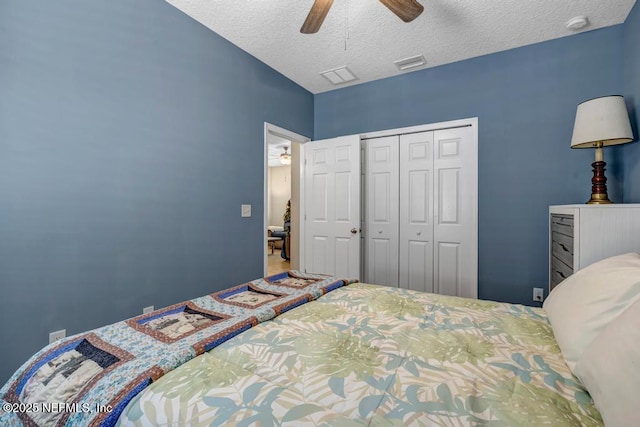 bedroom featuring ceiling fan, a closet, and a textured ceiling