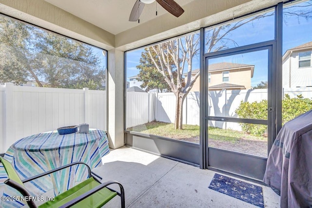 sunroom / solarium with a healthy amount of sunlight and ceiling fan