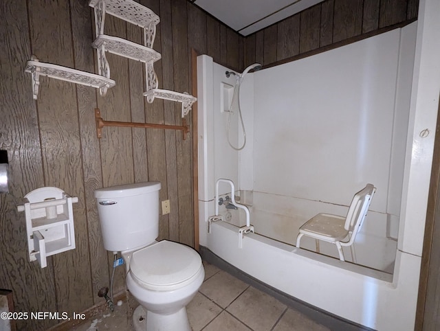 bathroom with tile patterned floors, shower / tub combination, toilet, and wooden walls