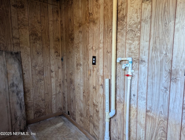 laundry room with wood walls