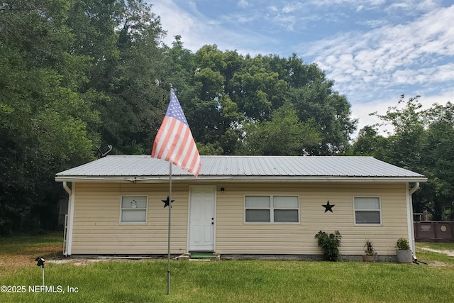 rear view of property featuring a yard