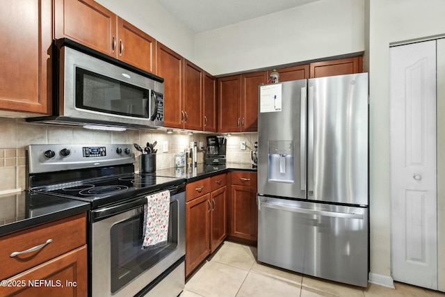 kitchen featuring backsplash, light tile patterned floors, and appliances with stainless steel finishes