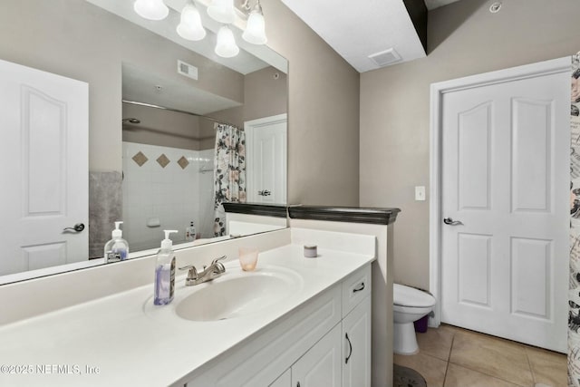 bathroom with tile patterned floors, vanity, toilet, and walk in shower