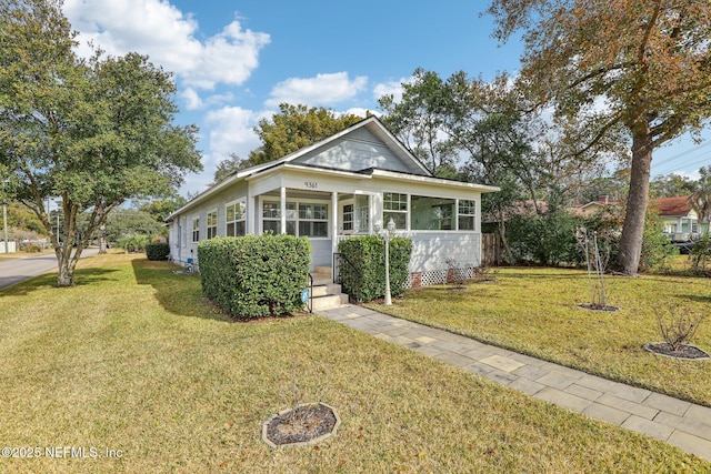 view of front of house featuring a front lawn and a sunroom