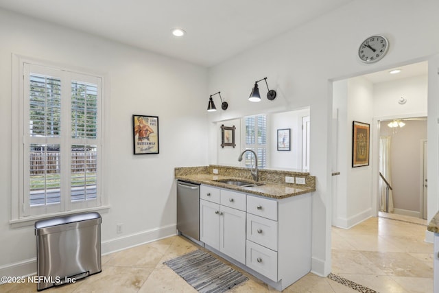 kitchen featuring sink, light tile patterned floors, dishwasher, and dark stone countertops