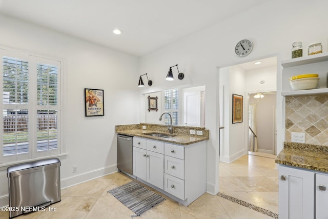 kitchen featuring sink, light tile patterned floors, dishwasher, and dark stone countertops