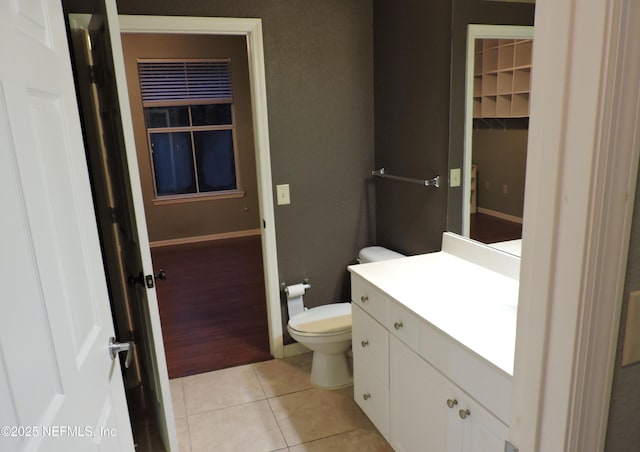 bathroom with toilet, vanity, and tile patterned flooring