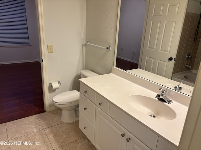 full bathroom with bathing tub / shower combination, toilet, vanity, and tile patterned flooring