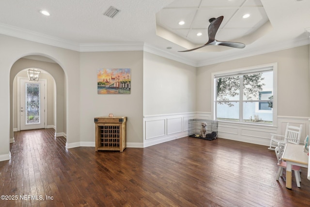 empty room featuring dark wood-type flooring, ceiling fan, and crown molding