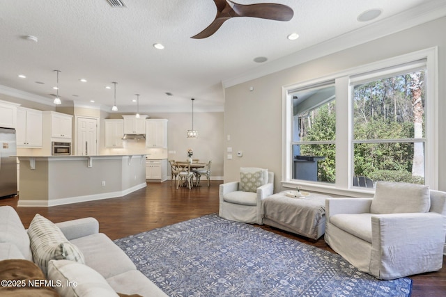 living room featuring ceiling fan, ornamental molding, dark hardwood / wood-style flooring, and a textured ceiling