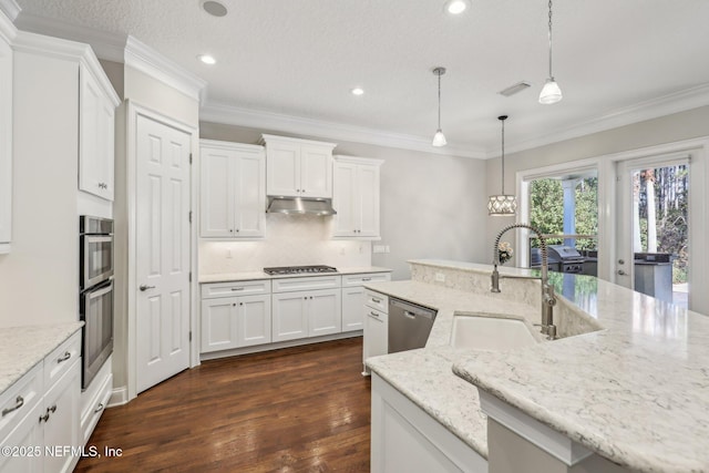 kitchen with sink, stainless steel appliances, light stone counters, white cabinets, and decorative light fixtures