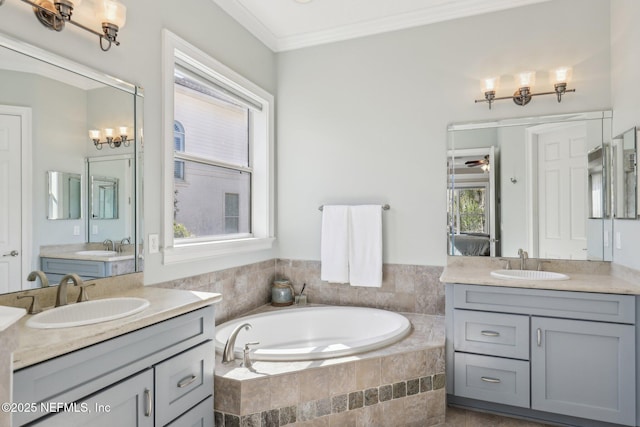 bathroom featuring ornamental molding, tiled bath, vanity, and ceiling fan