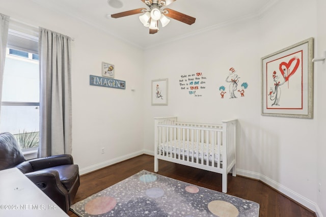 bedroom with multiple windows, dark hardwood / wood-style flooring, and a nursery area