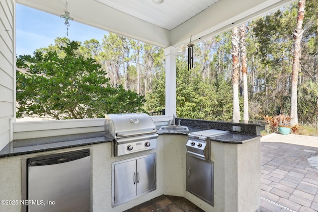 view of patio / terrace with an outdoor kitchen, sink, and area for grilling