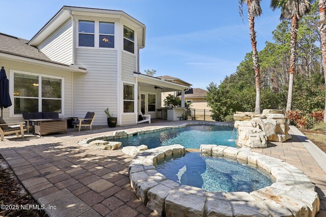 view of swimming pool featuring pool water feature, outdoor lounge area, ceiling fan, and a patio area