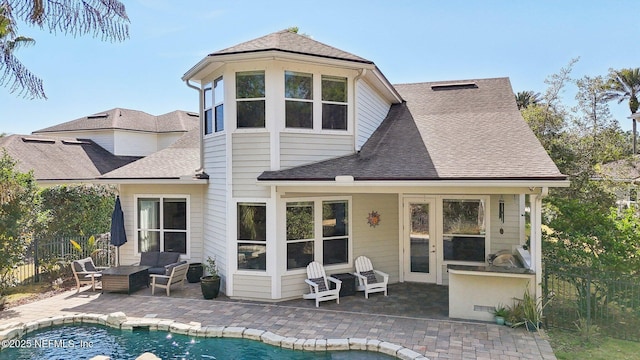 back of house featuring an outdoor living space, a fenced in pool, and a patio area