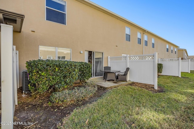 rear view of property with a lawn and a patio