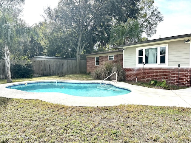 view of swimming pool featuring a lawn