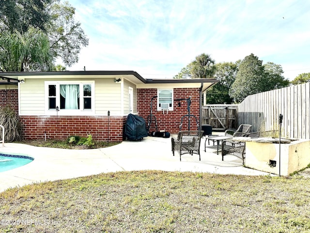 rear view of house featuring a lawn, a fenced in pool, and a patio