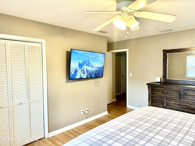 bedroom featuring ceiling fan, a textured ceiling, a closet, and hardwood / wood-style floors