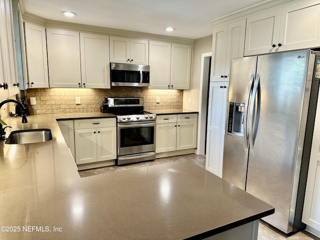 kitchen with white cabinets, backsplash, sink, and stainless steel appliances