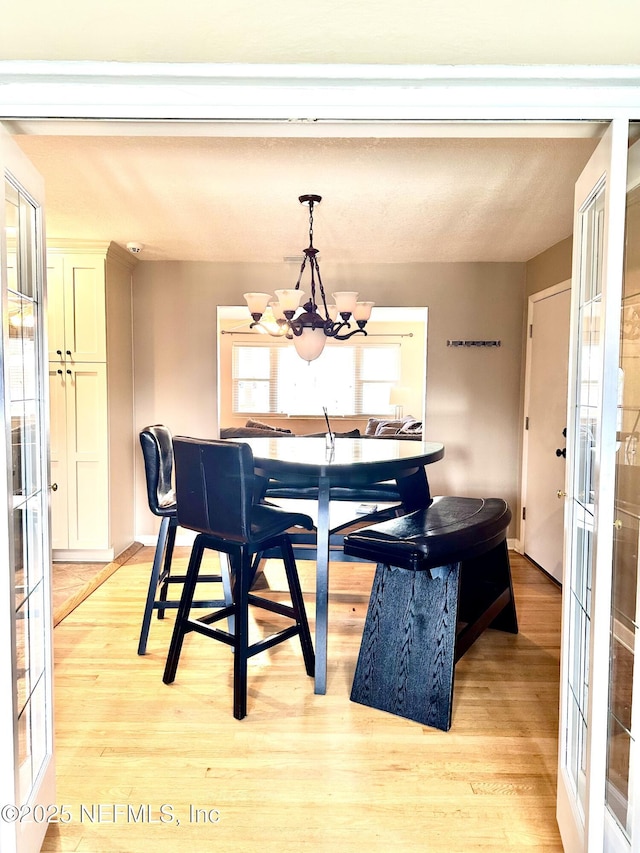 dining area with a chandelier and light hardwood / wood-style flooring