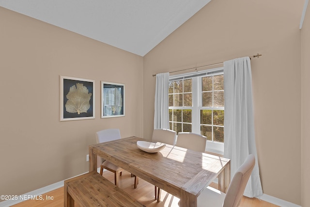 dining space with lofted ceiling and light hardwood / wood-style floors