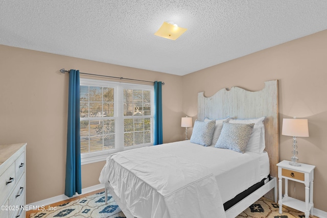 bedroom with a textured ceiling and baseboards