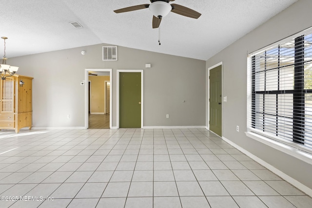 spare room featuring light tile patterned floors, lofted ceiling, and ceiling fan with notable chandelier