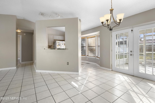 empty room featuring light tile patterned floors, french doors, vaulted ceiling, and an inviting chandelier